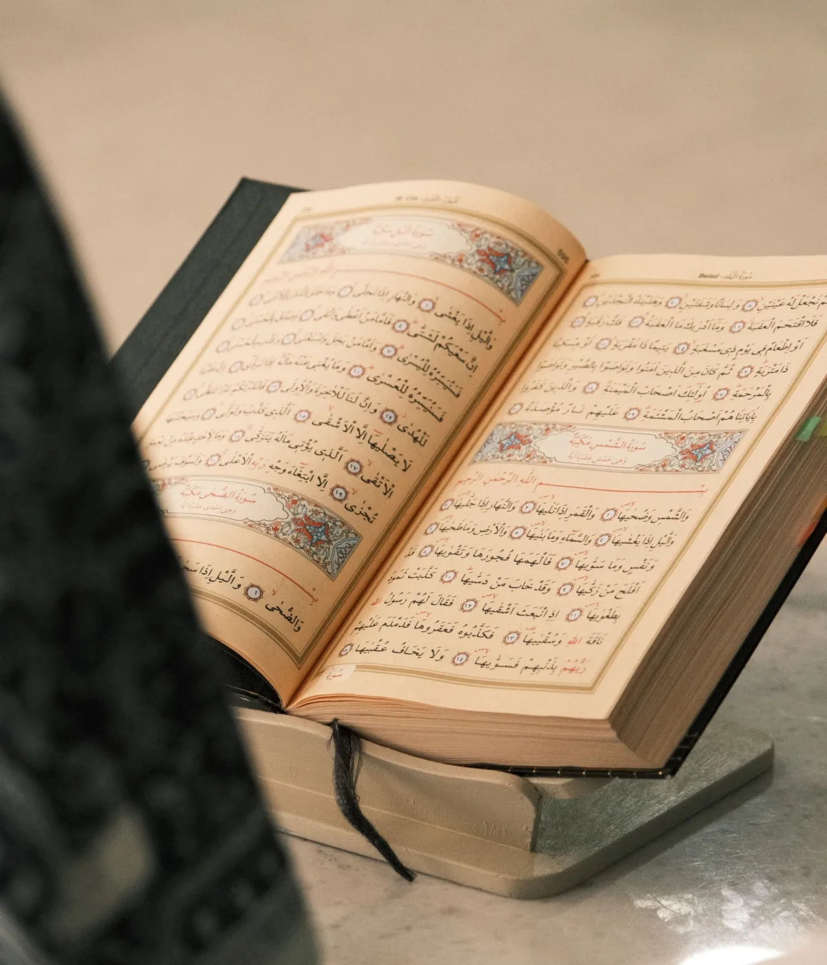 An open Quran resting on a wooden stand